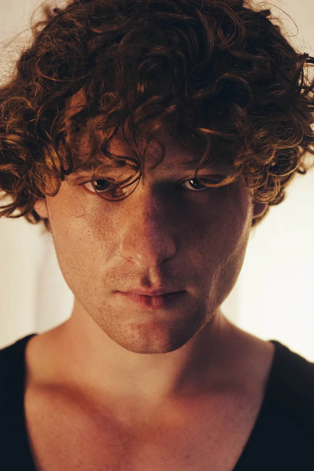 Close-up portrait in warm side light, looking into the camera